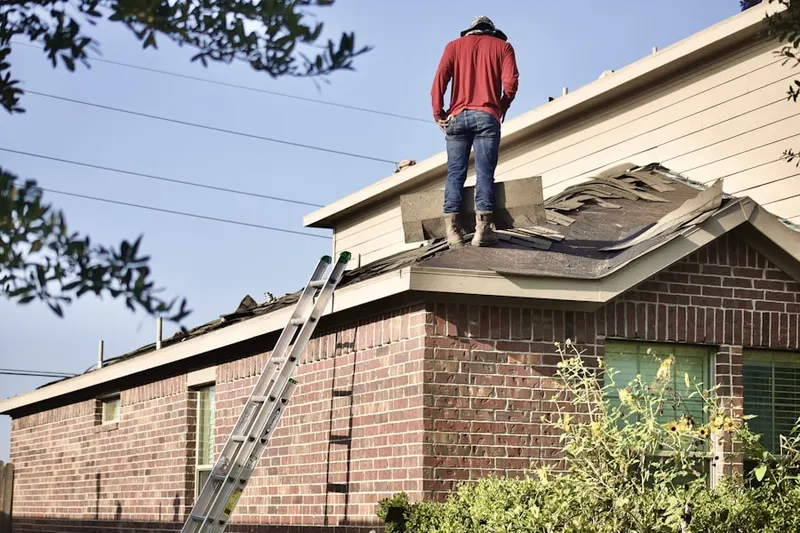 Professional roofer working on a residential roof in Burgee
